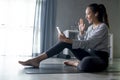 Sporty young Asian woman exercising at home, watching fitness video on Internet or having online fitness class Royalty Free Stock Photo