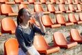 Sporty young attractive girl in sportswear relaxing after hard workout sit and drink water from special sport bottle after running Royalty Free Stock Photo