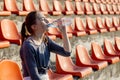 Sporty young attractive girl in sportswear relaxing after hard workout sit and drink water from special sport bottle after running Royalty Free Stock Photo