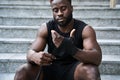 Sporty young black man sitting at urban stairs wrapping hands with boxing tape. Royalty Free Stock Photo