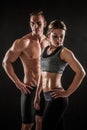 Sporty young couple posing on black background