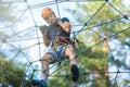 Sporty, young, cute boy in white t shirt spends his time in adventure rope park in helmet and safe equipment in the park Royalty Free Stock Photo