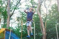 Sporty, young, cute boy in white t shirt spends his time in adventure rope park in helmet and safe equipment in the park Royalty Free Stock Photo