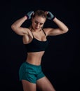 Sporty young girl in sportswear showing muscles on black background. Tanned young athletic woman. A great sport female body. Royalty Free Stock Photo