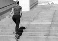 Sporty young girl in a top and leggings jogging ot the stairs. Pretty woman sporting. Concept of sport and health