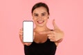 Sporty Young Lady Pointing At Big Blank Smartphone In Her Hand