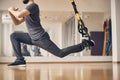 Sporty young male doing a TRX lunge Royalty Free Stock Photo