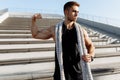 Sporty young man doing fitness workout outdoors, muscular man using two fighting ropes, sport, motivation