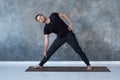 Sporty young man practicing yoga, doing stretching exercise, extended triangle pose Royalty Free Stock Photo