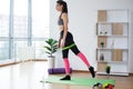 Sporty young woman doing squat morning exercise alone in living room Royalty Free Stock Photo