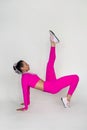 Sporty young woman doing stretching exercises in tracksuit isolated on pink background. Royalty Free Stock Photo