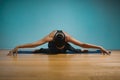 Sporty young woman doing stretching. Slim girl practicing yoga indoors on blue background. Calm, relax, healthy Royalty Free Stock Photo