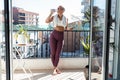 Sporty young woman drinking water while taking a break of doing exercise in balcony at home Royalty Free Stock Photo