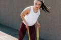 Sporty young woman exercising with resistance band on a sunny day. Athlete female working out with elastic bands outside Royalty Free Stock Photo