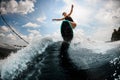 Sporty young woman jumping on the board on the river wave Royalty Free Stock Photo