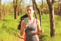 Sporty young woman listening to music while running in park Royalty Free Stock Photo