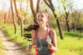 Sporty young woman listening to music while running in park Royalty Free Stock Photo