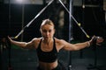 Sporty young woman with perfect muscular body working out on simulator during sport training at gym Royalty Free Stock Photo