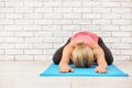 Sporty young woman practicing yoga on mat indoors Royalty Free Stock Photo