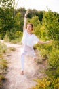 Sporty young woman practicing yoga on park outside the city. Meditative lady enjoying meditation Royalty Free Stock Photo