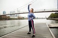 Sporty young woman in in sportswear doing stretching exercises on a wooden pier near the river Royalty Free Stock Photo