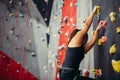 Sporty young woman training in a colorful climbing gym. Royalty Free Stock Photo