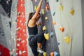 Sporty young woman training in a colorful climbing gym. Royalty Free Stock Photo