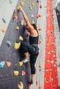 Sporty young woman training in a colorful climbing gym. Royalty Free Stock Photo