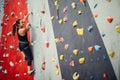 Sporty young woman training in a colorful climbing gym. Royalty Free Stock Photo