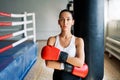 Sporty young woman wearing boxing gloves posing in gym Royalty Free Stock Photo