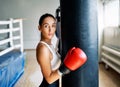 Sporty young woman wearing boxing gloves posing in gym Royalty Free Stock Photo