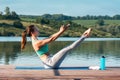 Sporty young woman doing stretching while sitting in Paripurna Navasana exercise, balance posture. Beautiful athletic girl Royalty Free Stock Photo