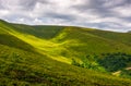 Spot of light on green hillside on overcast day