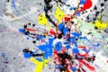 A spot of white and black and yellow and green and red and blue spilled paint on a concrete textured surface Royalty Free Stock Photo