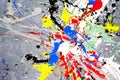 A spot of white and black and yellow and green and red and blue spilled paint on a concrete textured surface Royalty Free Stock Photo