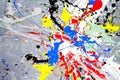 A spot of white and black and yellow and green and red and blue spilled paint on a concrete textured surface Royalty Free Stock Photo