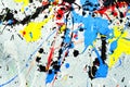 A spot of white and black and yellow and green and red and blue spilled paint on a concrete textured surface Royalty Free Stock Photo