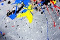 A spot of white and black and yellow and green and red and blue spilled paint on a concrete textured surface Royalty Free Stock Photo