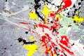 A spot of white and black and yellow and green and red spilled paint on a concrete textured surface Royalty Free Stock Photo