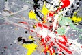 A spot of white and black and yellow and green and red spilled paint on a concrete textured surface Royalty Free Stock Photo