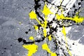A spot of white and black and yellow spilled paint on a concrete textured surface Royalty Free Stock Photo