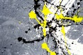 A spot of white and black and yellow spilled paint on a concrete textured surface Royalty Free Stock Photo
