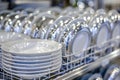 Spotless white dishes neatly organized in a dishwasher within a contemporary kitchen setting Royalty Free Stock Photo