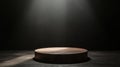 Spotlight highlights a circular wooden platform in a dark studio setting for creative presentations Royalty Free Stock Photo