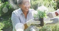 Spots of light against african american senior couple gardening together in the garden Royalty Free Stock Photo