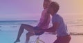 Spots of light against african american young couple riding in a bicycle together at the beach Royalty Free Stock Photo