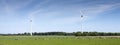 Spotted cows and wind turbines in dutch province of flevoland under blue sky in spring Royalty Free Stock Photo