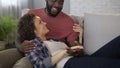 Spouse telling his wife funny stories, happy people enjoying relax at home