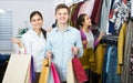 Spouses carrying bags in boutique