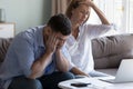 Spouses manage finances, analyze expenses, check budget looks disappointed
